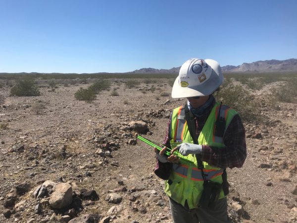 Wildlife biologist enters data on a tablet in the Mojave Desert.