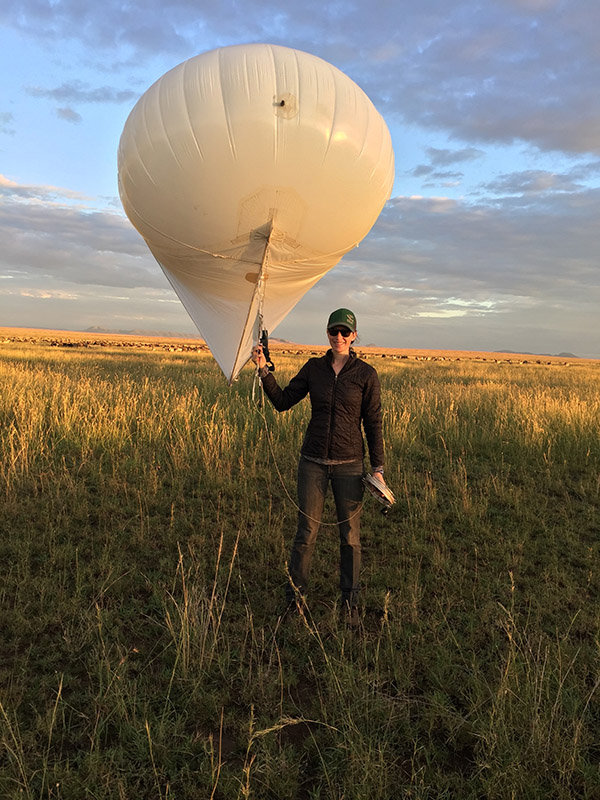 Researcher Lacey Huey holding a tethered aerostat to collect aerial images.