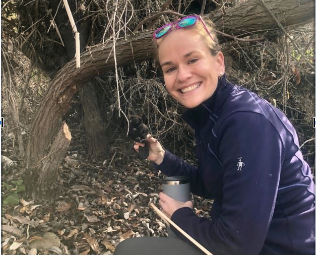 Dr. Emily Fairfax holds a baby beaver at a beaver complex